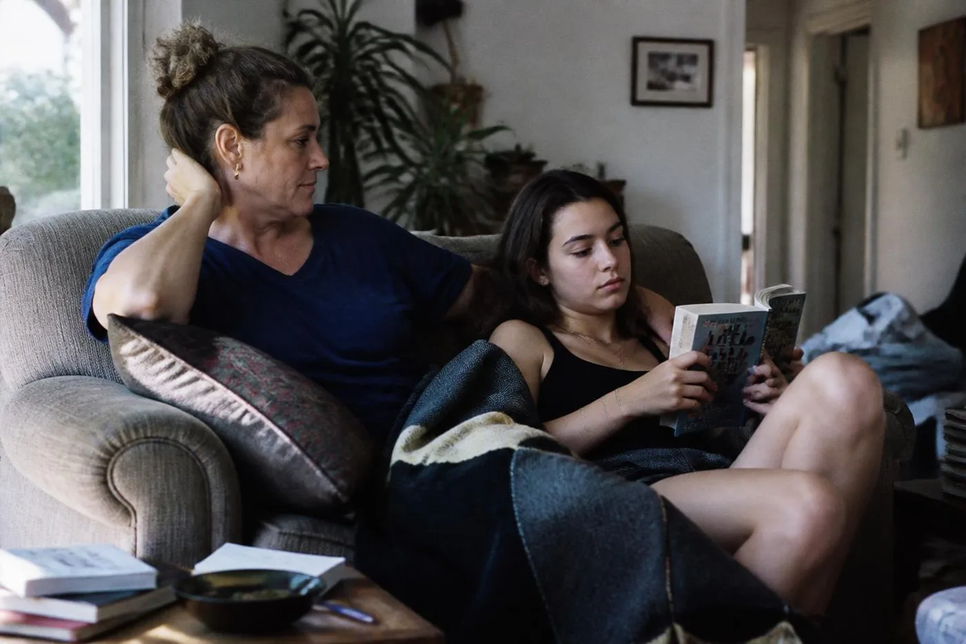 Mother and daughter relaxing on the sofa in their living room on a warm afternoon