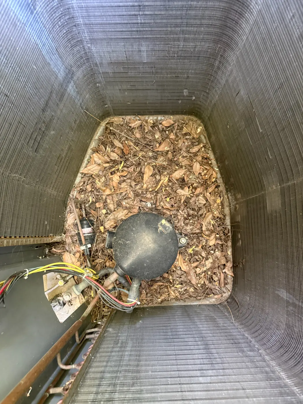 Blower compartment of an air handler filled with debris before cleaning