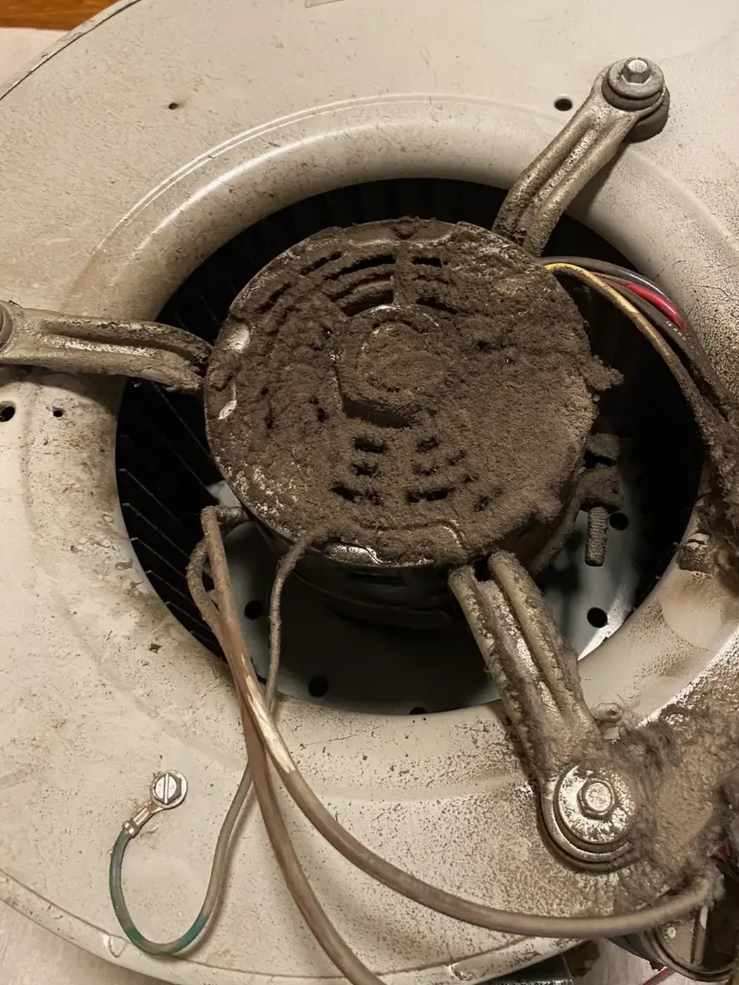 Blower motor and wheel heavily coated in rust and dust before service