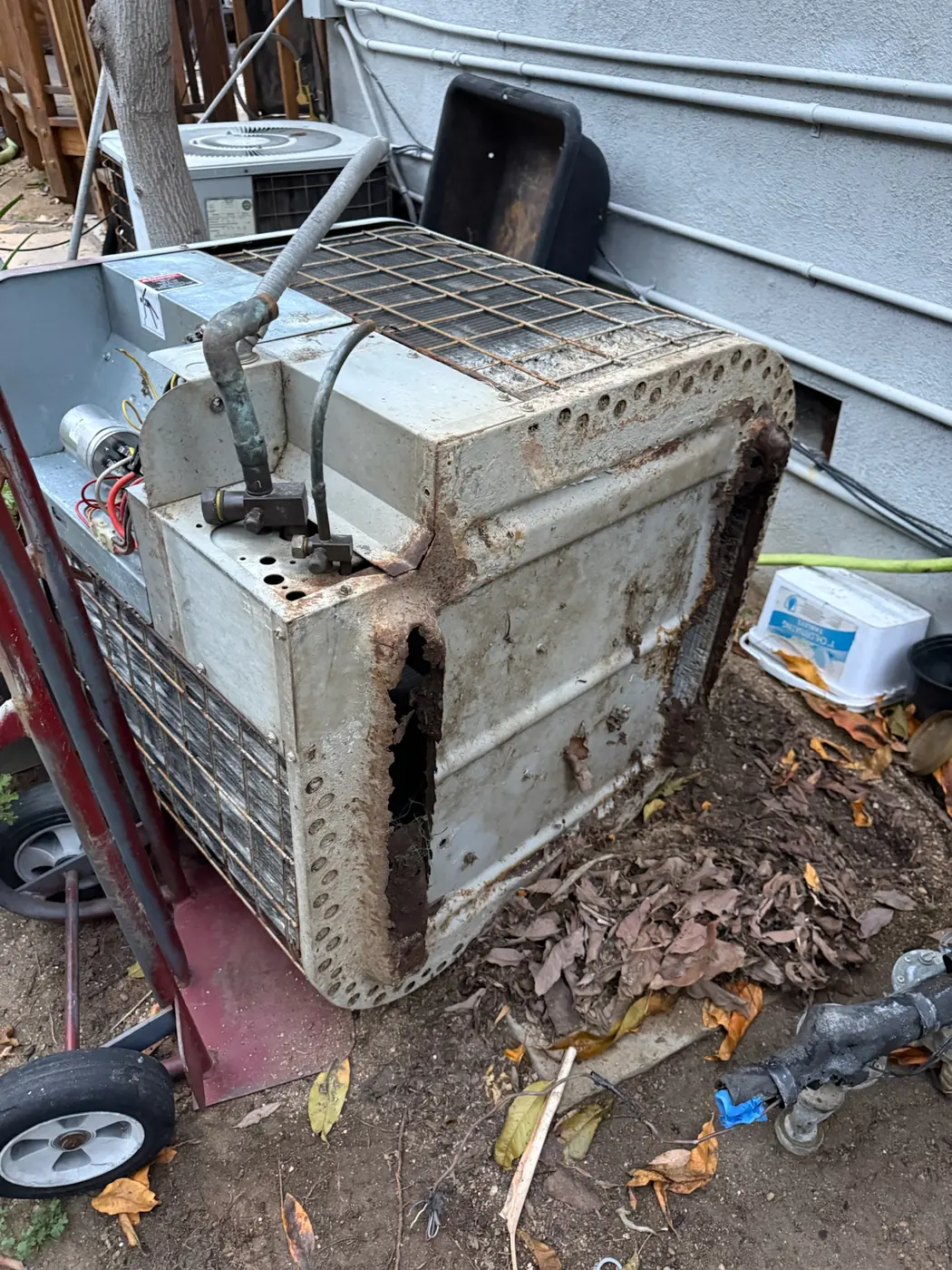 Aging outdoor condensing unit with a rusted cabinet and bent coil fins