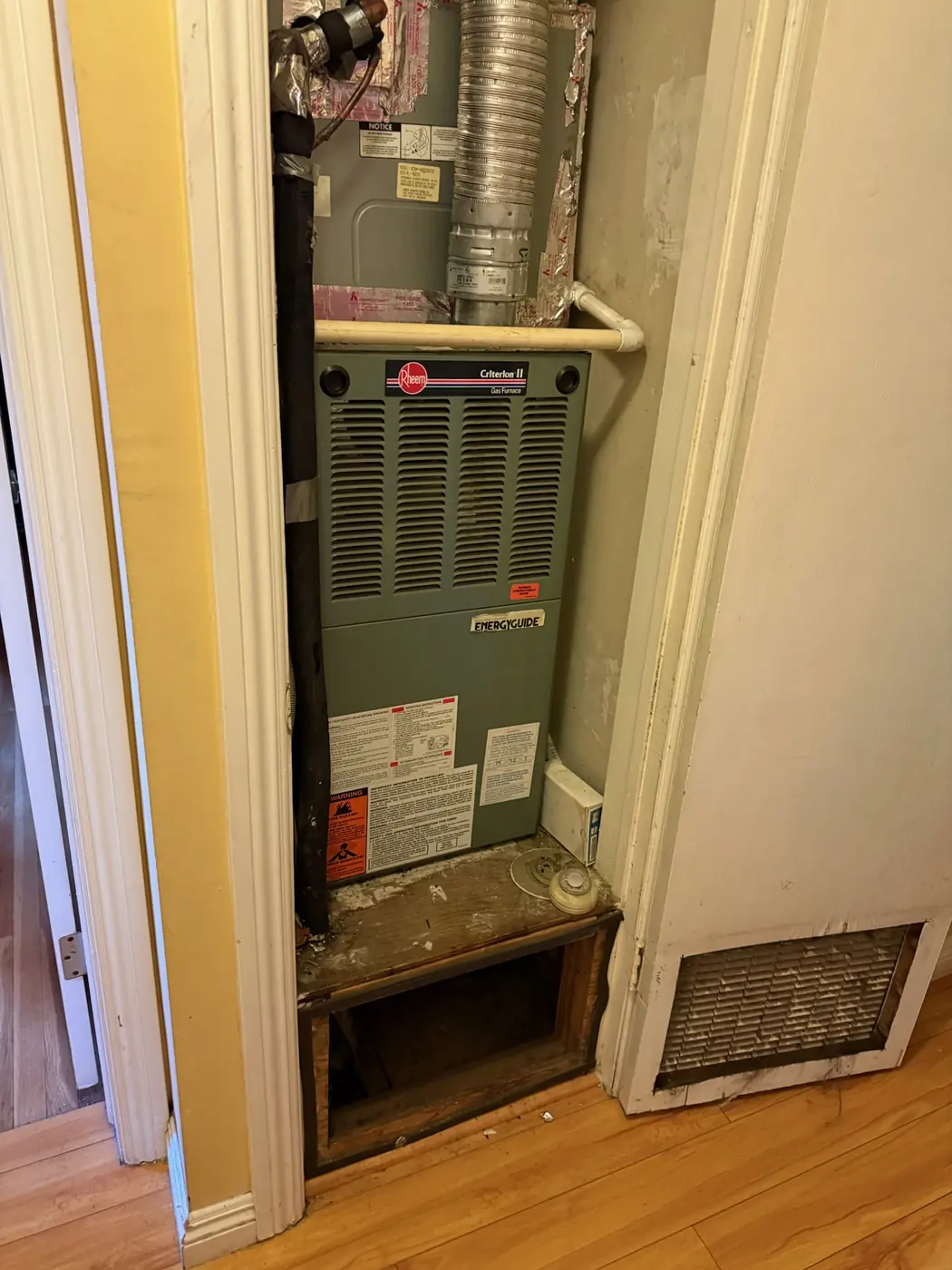 Gas furnace installed in an indoor hallway closet with the return grille below
