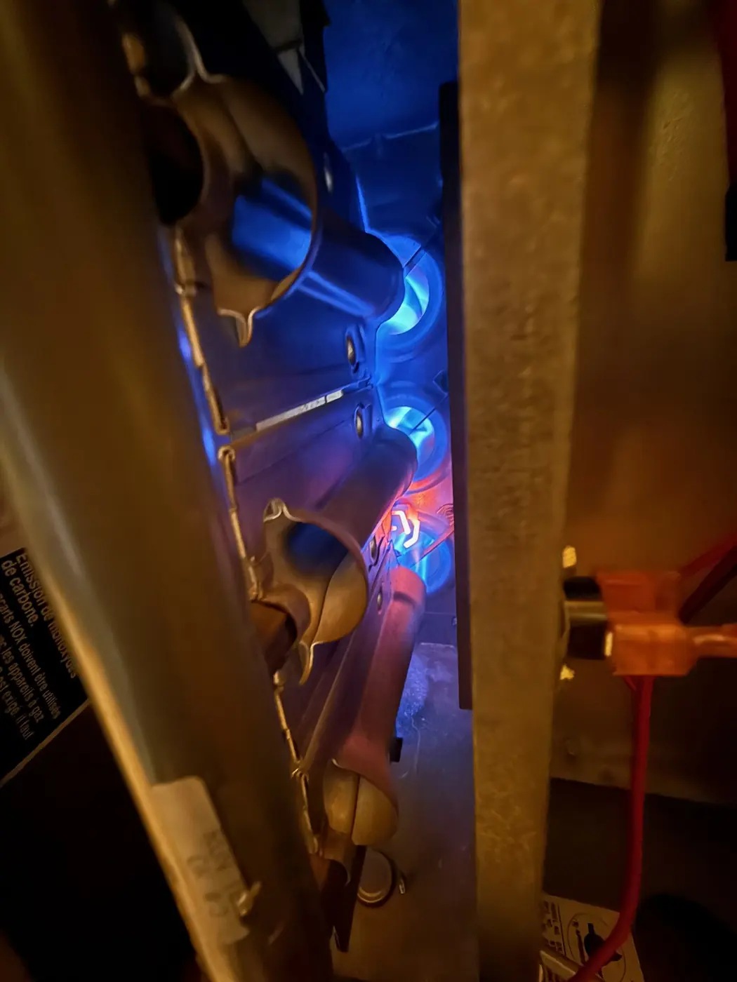 Blue burner flames visible through the inspection port of a gas furnace