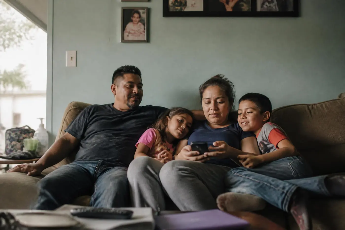 Family sitting together on the couch in their living room on a warm afternoon